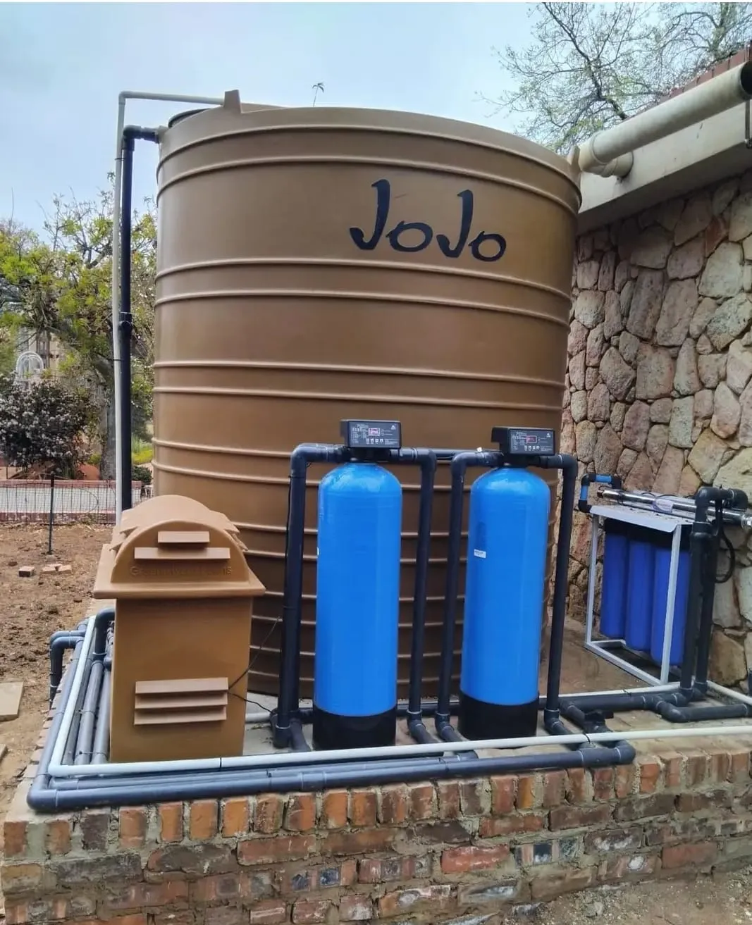 JoJo tank with blue filter vessels and a pump cover on a brick base